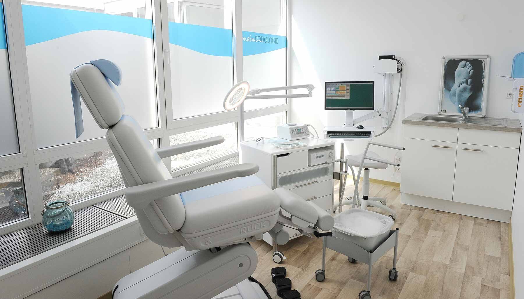 Behandlungsraum der Main-Podologie mit Behandlungsstuhl am Fenster